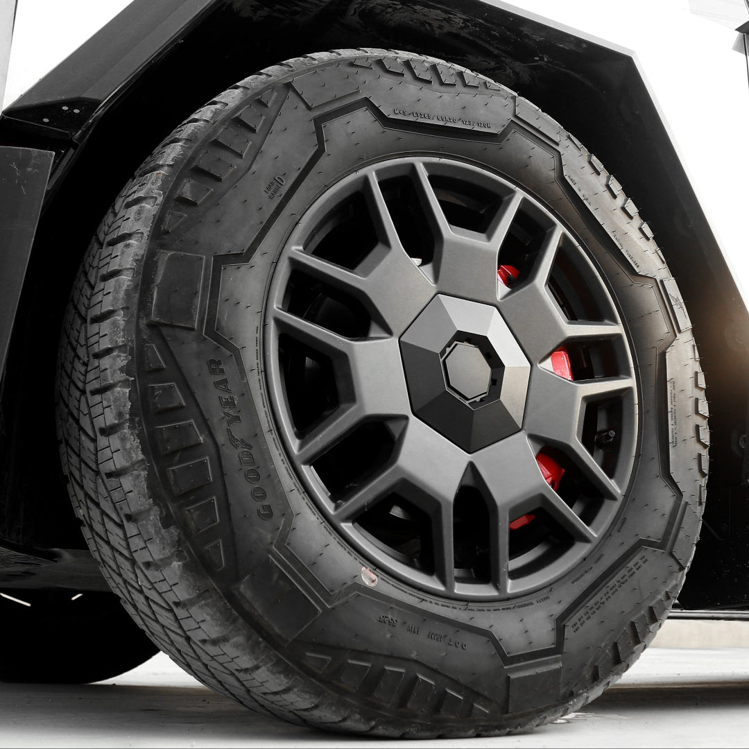 Close-up of a black tire with a detailed tread pattern on a vehicle.